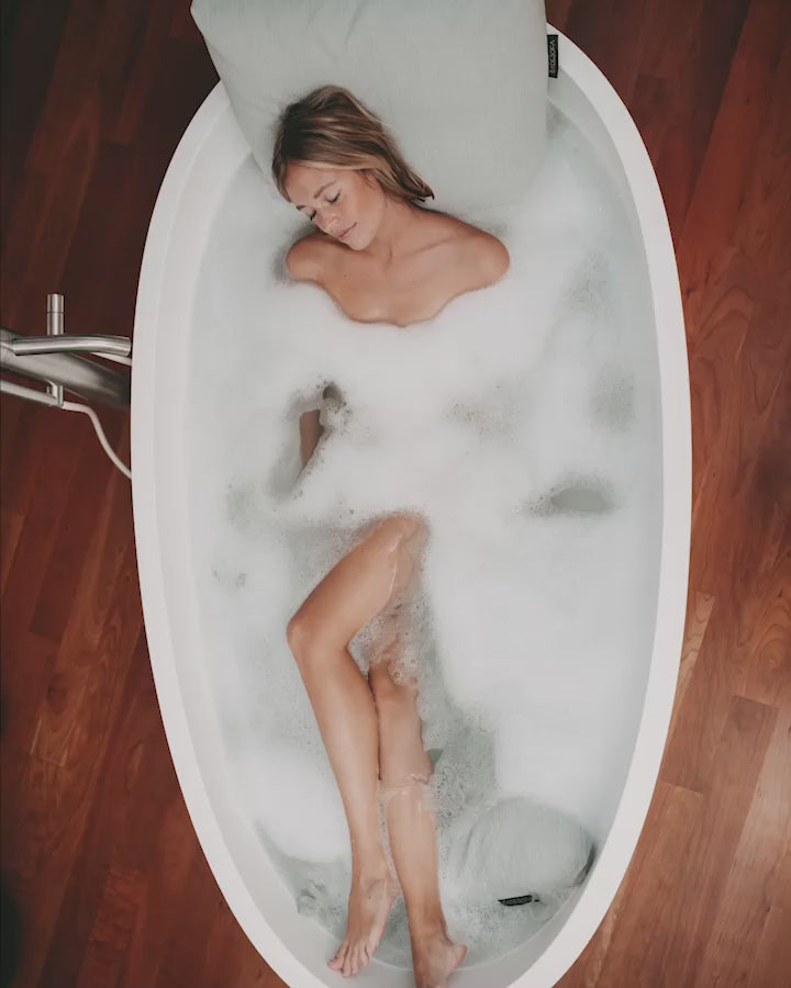 Das Video begleitet eine Frau, die ihr Vollbad mit einem Badesofa Rückenkissen und Fußkissen in einer freistehenden Badewanne genießt